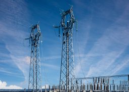 Electric high voltage pylons on Power station electric distribution center over blue sky with streaky clouds, copy space Electric high voltage pylons on Power station electric distribution center over blue sky with streaky clouds, copy space